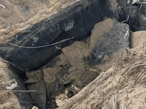 Underground pipe excavation exposing a damaged sewer line