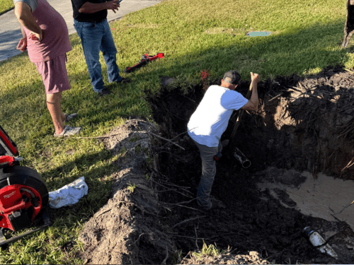 LCI plumber working in an excavated trench during a sewer line repair
